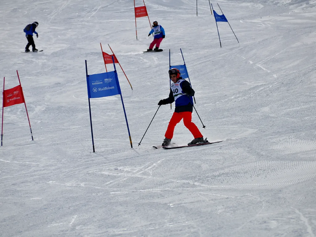 Skifahrer im Slalomkurs, im Hintergrund weitere Fahrende.